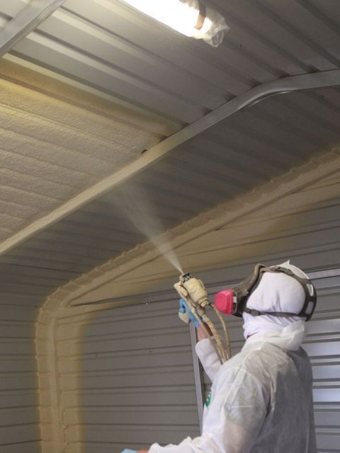 Spray foam being applied to the underside of a metal roof deck