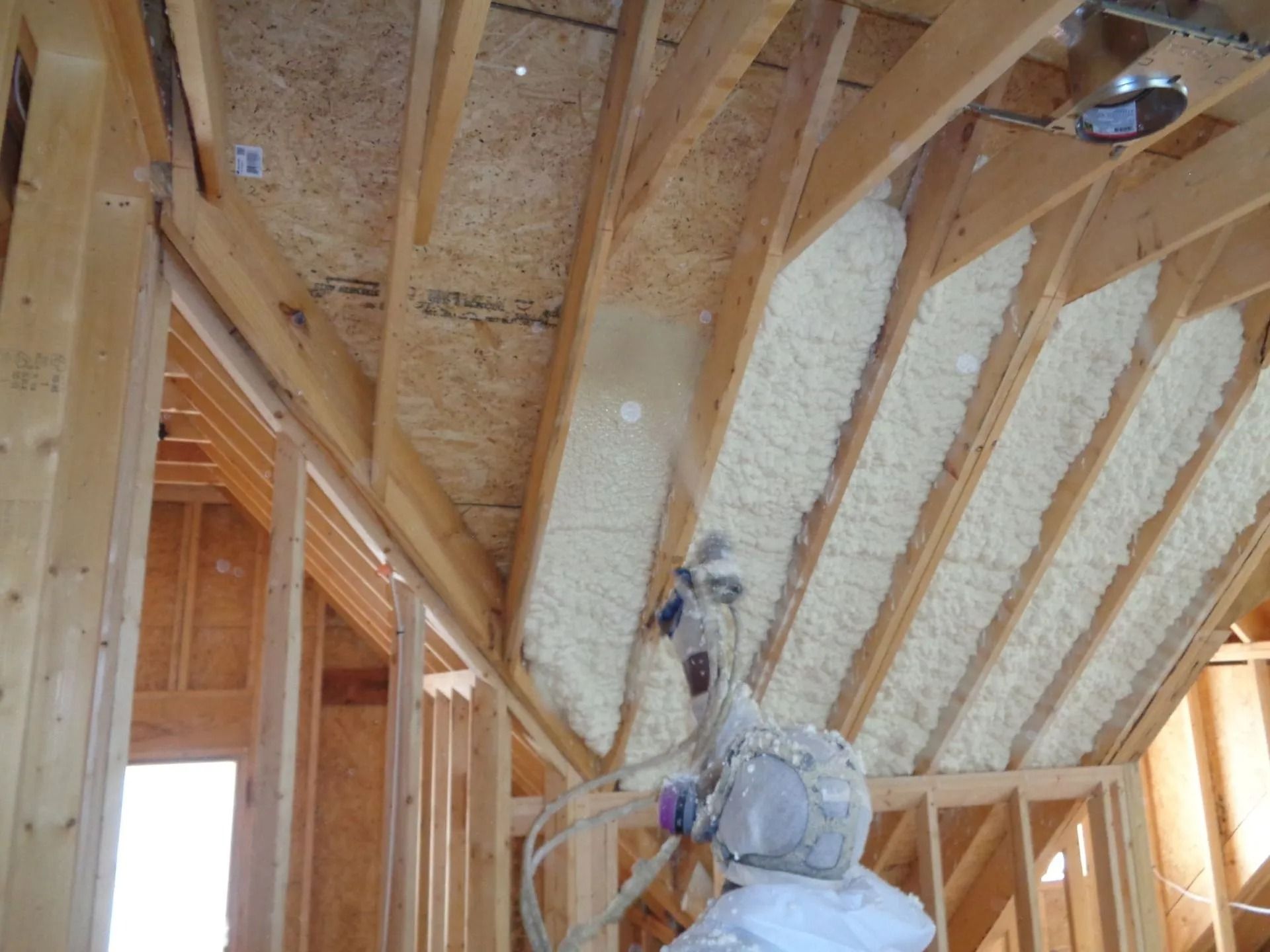 Spray foam insulation filling the stud cavities of a new home