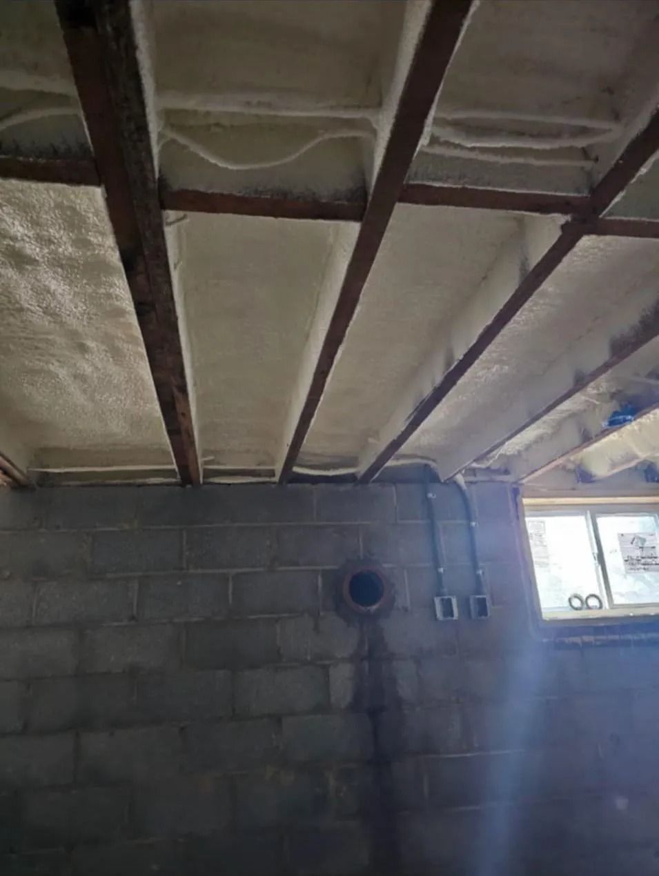 Spray foam applied to a basement ceiling and rim joists